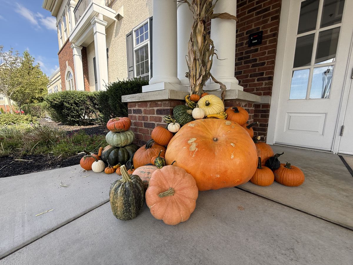 The Estate: a giant pumpkin surrounded by heirlooms beside a corn-stalk-wrapped column