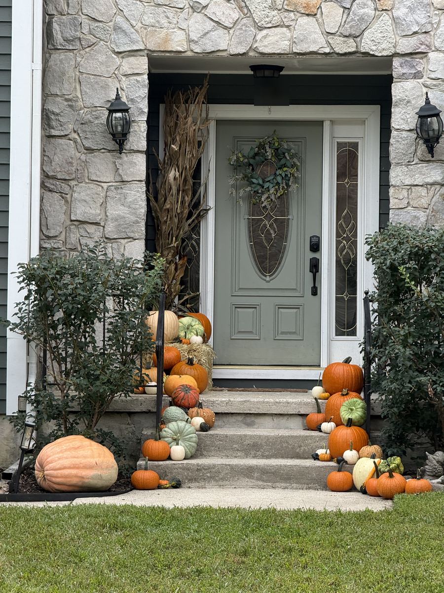Grove St.: full front-step display with hay bale and corn stalks at a stone entry